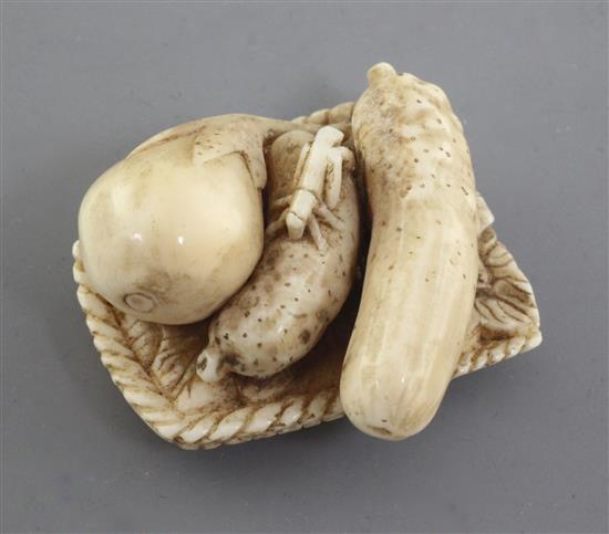 A Japanese ivory netsuke of vegetables on a woven tray, Meiji period, signed Komei, l. 3.7cm